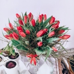 Kompozycja kwiatowa stworzona z czerwonych tulipanów przybranych delikatną dekoracją - Bukiet Barwy Miłości